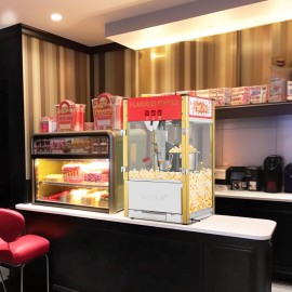 The popcorn machine is equipped with an 8-ounce water bottle and can make up to 32 cups. It is a commercial popcorn machine with a tabletop, featuring a stainless steel spoon, an oil spoon and 3 popcorn cups. It is suitable for home theaters and is black